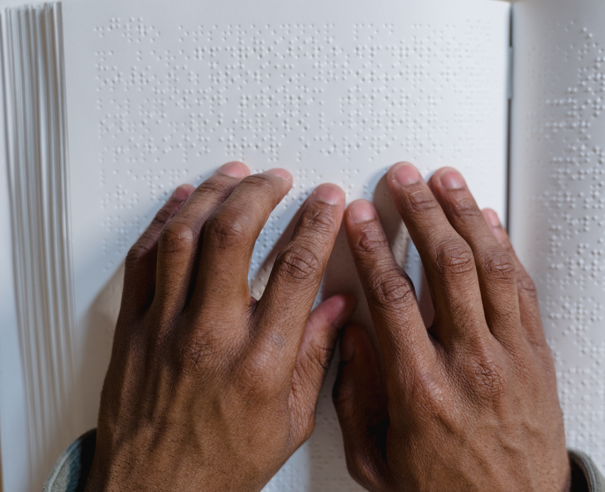 hands reading a braille book